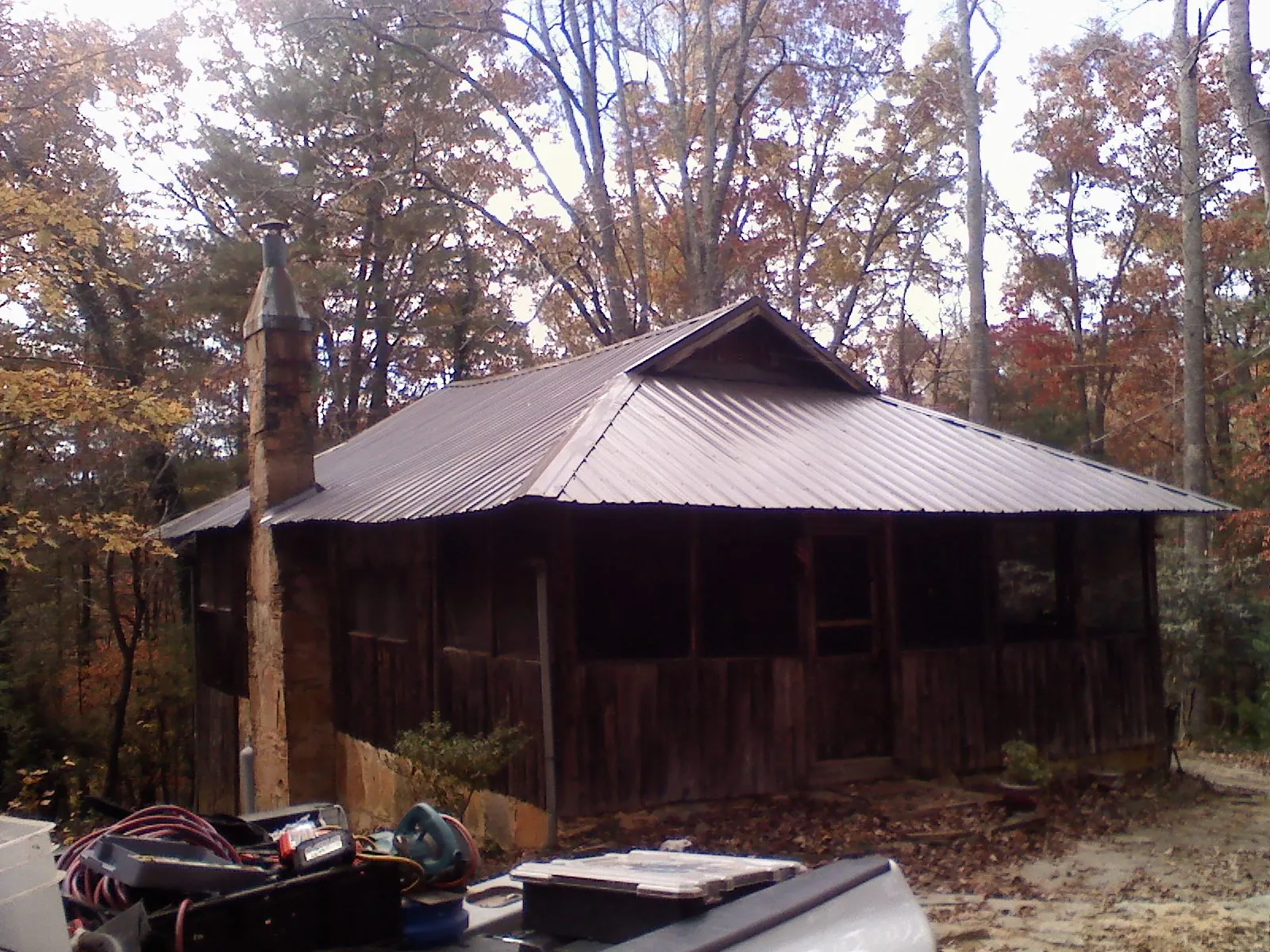 Brown metal hip roof on an old cabin with a stone chimney in Puyallup