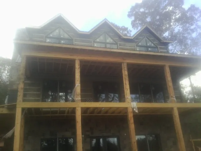 Dormers and porch framing on a large log home under construction — Roof Coating work by our crew in Puyallup