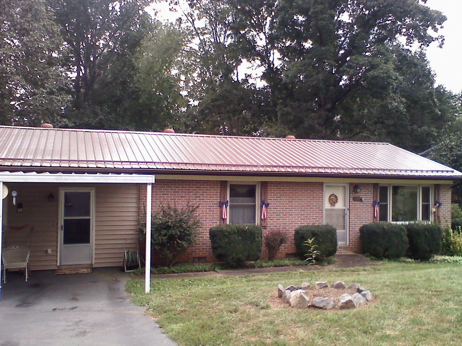 Bronze metal roof and carport on a brick ranch home — Roof Repair work by our crew in Puyallup